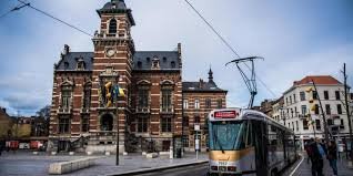 Plombier Anderlecht: Rue animée avec maisons anciennes et canal, typiques d'Anderlecht en arrière-plan.