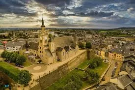 Plombier Arlon rue piétonne animé avec façades historiques et enseignes, typique du centre-ville belge.