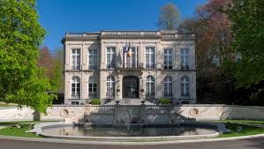 Plombier Auderghem devant le viaduc Herrmann-Debroux, scène urbaine avec bâtiments typiques et végétation luxuriante.