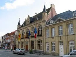 Plombier Comines-Warneton près du clocher historique de la ville avec rues pavées et architecture locale typique