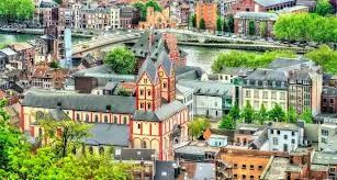 Débouchage Liège devant la cathédrale Saint-Paul sous un ciel ensoleillé et rues pittoresques de la vieille ville.
