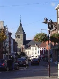 Plombier Tubize, rue animée près de la Gare de Tubize avec maisons en briques rouges typiques et commerces locaux.