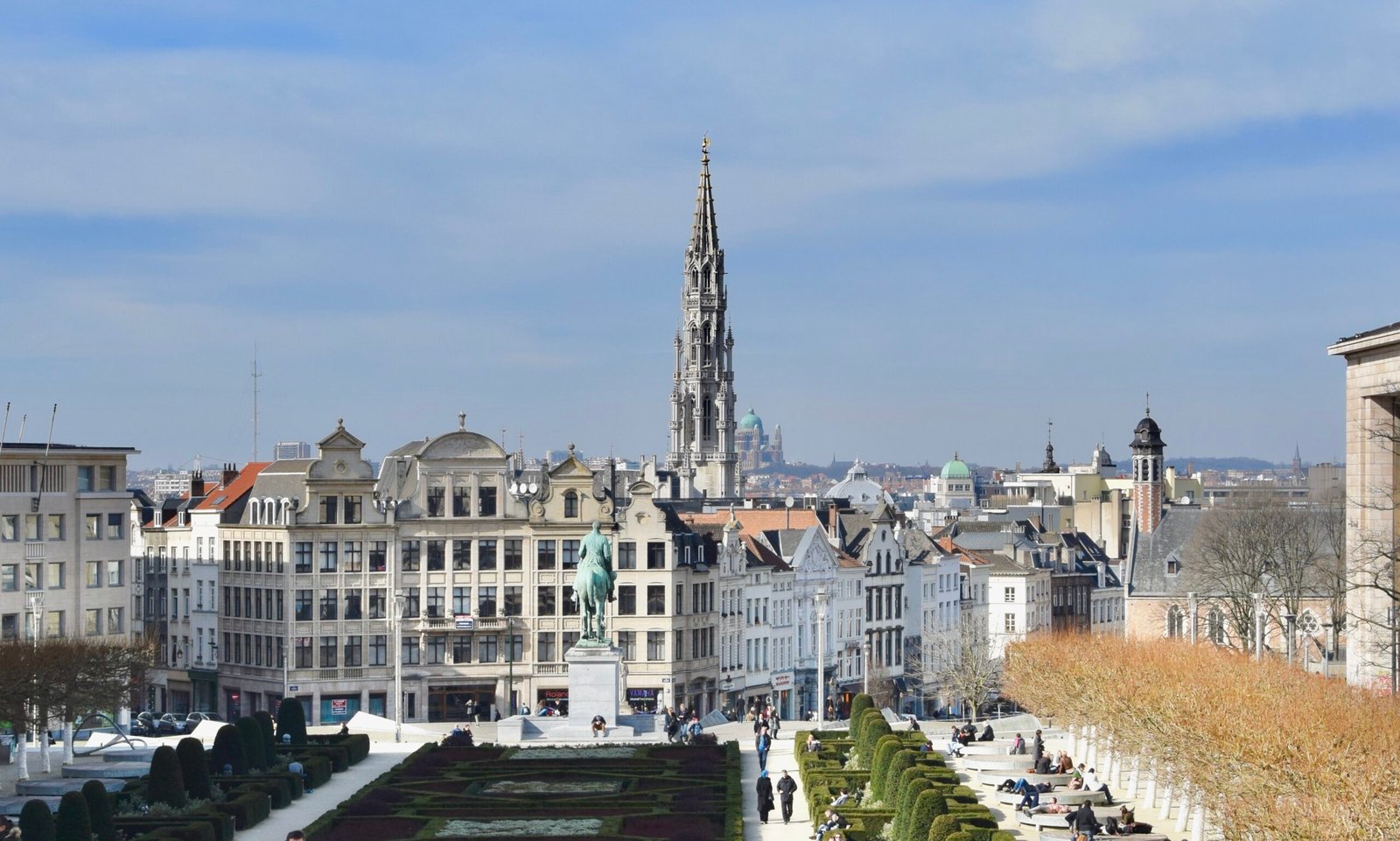 Un plombier à Bruxelles avec outils devant la Grand-Place, architecture gothique des bâtiments historiques en arrière-plan.